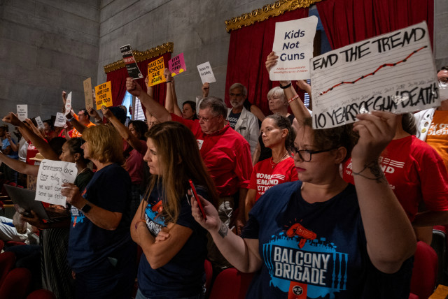  Supporters of gun reform hold signs in the gallery seating in the House Chamber of the Tennessee State Capitol building during a special session on public safety to discuss gun violence in the wake of the Covenant School shooting in Nashville, Tennessee, U.S., August 21, 2023. (credit: REUTERS/SETH HERALD)