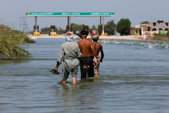  Displaced people walk on flooded highway, following rains and floods during the monsoon season in Sehwan, Pakistan, September 16, 2022. (credit: Akhtar Soomro/Reuters)