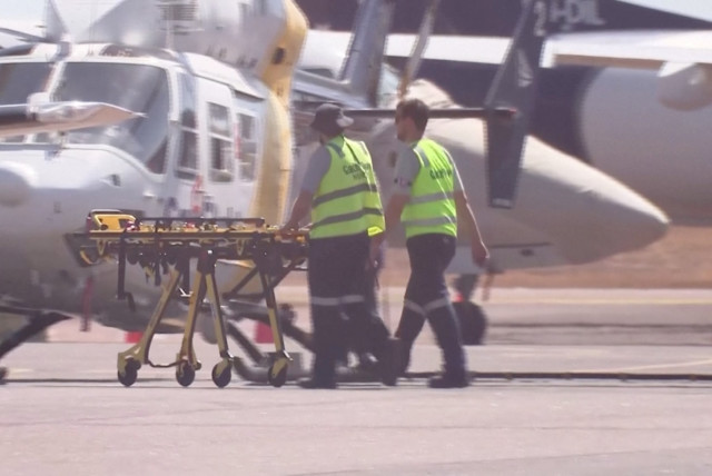  Paramedics push a stretcher following U.S. military aircraft crash in Darwin, Australia, August 27, 2023. (credit: AUSTRALIAN BROADCASTING CORPORATION/via Reuters TV/Handout via REUTERS)