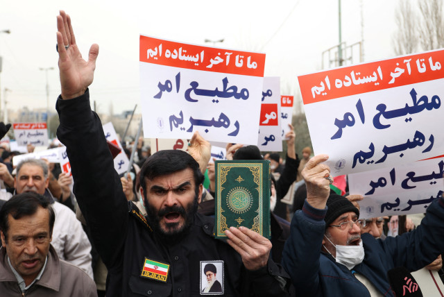  An Iranian protester holds the Quran in his hand during a protest to denounce the recent desecration of the Quran by far-right activists in Sweden, in Tehran, Iran, January 27, 2023.  (credit: Majid Asgaripour/WANA via Reuters)