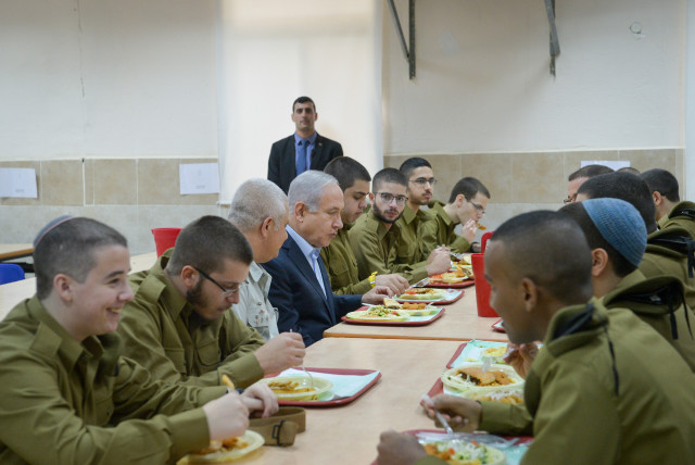 Prime Minister Benjamin Netanyahu eats with newly recruited Israeli soldiers during his visit at the Tel Hashomer army base on November 26, 2018 (credit: AVI DISHI/FLASH90)
