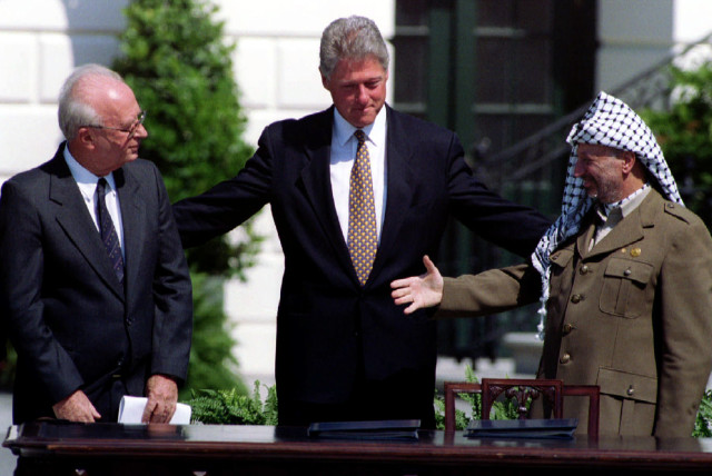  President Clinton brings Israeli Prime Minister Yitzhak Rabin (L) and PLO Chairman Yasser Arafat together for an historic handshake after the signing of the Israeli-PLO peace accord at the White House Sept. 13. 1993 (credit: REUTERS)