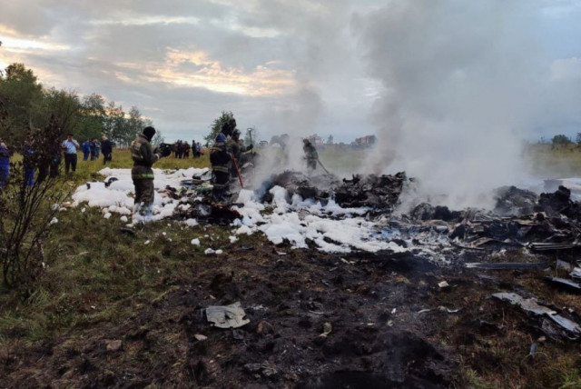  Firefighters work amid aircraft wreckage at an accident scene following the crash of a private jet in the Tver region, Russia, August 23, 2023. (credit: Investigative Committee of Russia/Handout via REUTERS)