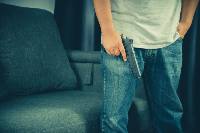  Men wearing t-shirts, jeans Standing holding a gun in the house (credit: INGIMAGE)