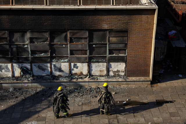  Firefighters walk at the scene of a deadly blaze, in Johannesburg, South Africa August 31, 2023. (credit: REUTERS/SIPHIWE SIBEKO)