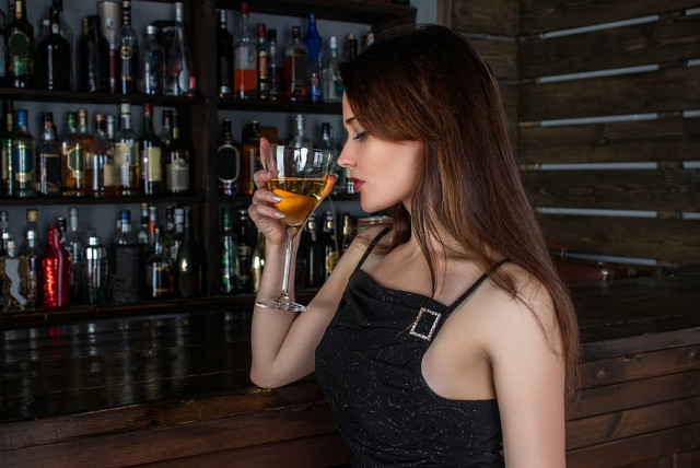  A woman drinking in a bar. (credit: WALLPAPER FLARE)