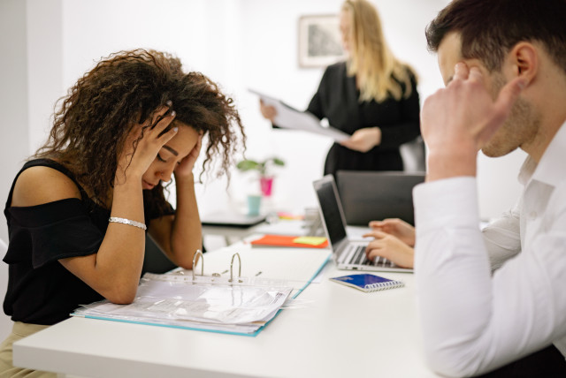   Stressed workers in an office. (credit: PEXELS)