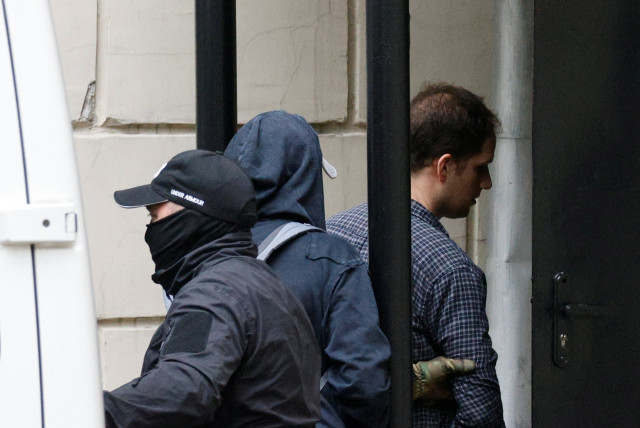 Wall Street Journal reporter Evan Gershkovich, who was arrested in March while on a reporting trip and accused of espionage, is escorted into a court building before a hearing on extending his pre-trial detention, in Moscow, Russia August 24, 2023. (credit: REUTERS/MAXIM SHEMETOV)