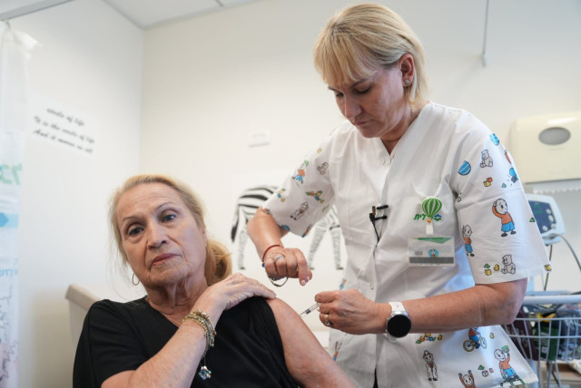 Woman gets vaccinated. (photo credit:  Rami Zerneger for Clalit Healthcare Services)