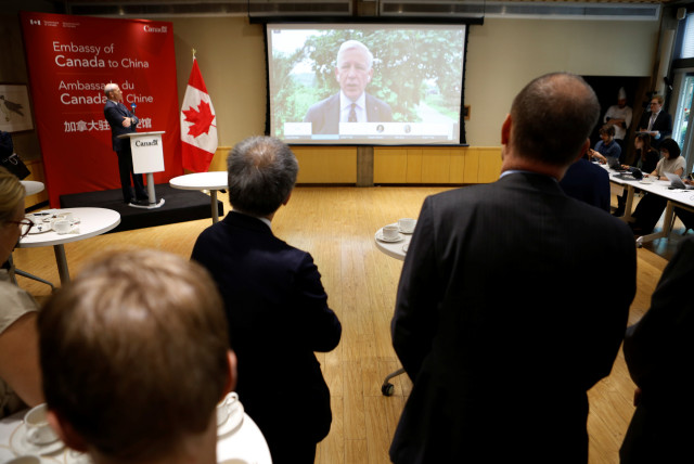  Canadian Ambassador to China Dominic Barton speaks to journalists and diplomats via video link from Dandong, where a local court ruled on the case of Michael Spavor, charged with espionage in June 2019, at the Canadian embassy in Beijing, China August 11, 2021 (credit: REUTERS)