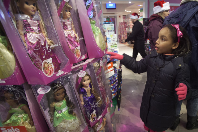  A girl looks at items from Disney's Princess toy line at the Toys R Us store in Times Square in New York November 27, 2014. (credit: REUTERS)