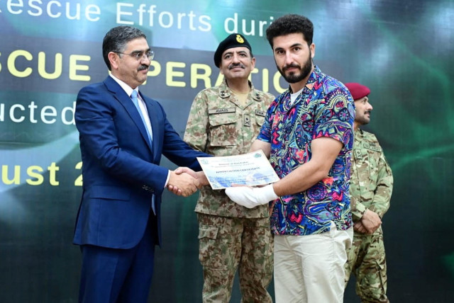  Pakistan's caretaker Prime Minister Anwaar-ul-Haq Kakar awards appreciation certificate to rescuer Mohammad Ali, zipline rescuer of Battagram chairlift incident, during a ceremony at Prime Minister House in Islamabad, Pakistan, August 24, 2023.