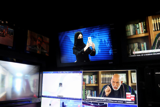  A female presenter for Tolo News takes a selfie in a newsroom while her face is covered at Tolo TV station in Kabul (credit: REUTERS)