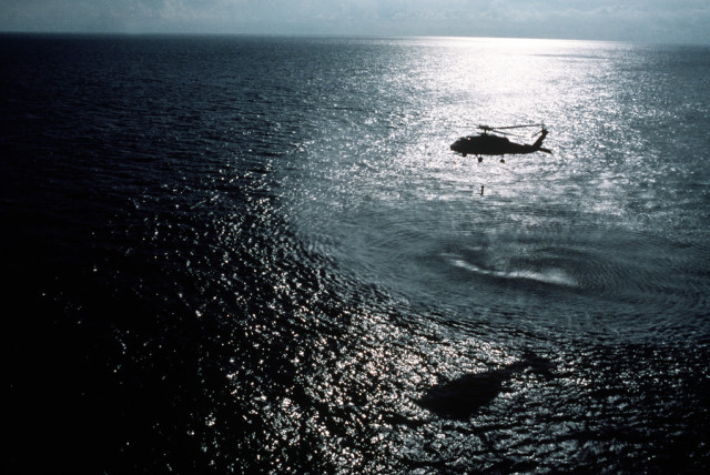  A helicopter hovers over the sea at night (Illustrative).  (credit:  NARA & DVIDS Public Domain Archive)
