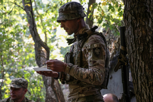  A Ukrainian serviceman eats, at a position in a front line near the town of Bakhmut, amid Russia's attack on Ukraine, in Donetsk region, Ukraine September 19, 2023. (credit: REUTERS/OLEKSANDR RATUSHNIAK)