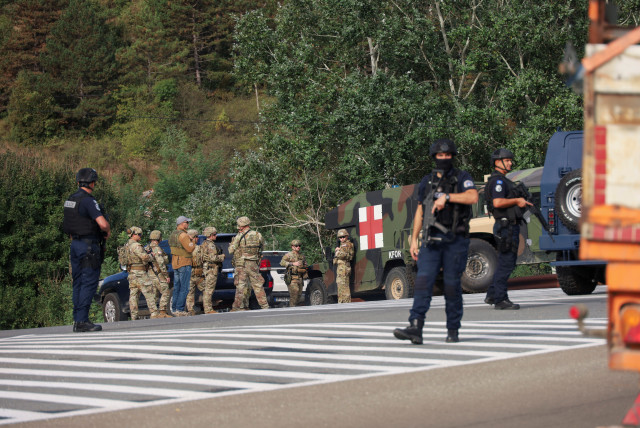  People work as Kosovo police and US and EU troops stand by after one police officer was killed, another hurt in Kosovo gunfire, in Josevik, Kosovo September 24, 2023. (photo credit: REUTERS/FATOS BYTYCI)