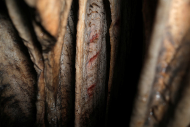  Red ocher markings which were painted on stalagmites by Neanderthals about 65,000 years ago, according to an international study, are seen in a prehistoric cave in Ardales, southern Spain, August 7, 2021. (credit: REUTERS/JON NAZCA)