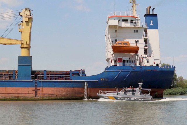   A Cargo ship sails followed by a Ukraine’s Coast Guard cutter through Bystre rivermouth, which connects the Black Sea and Danube, at a location given as Izmail district of Odesa region, Ukraine in this screen grab obtained from a handout video released on July 15, 2022 (photo credit: OPERATIONAL COMMAND SOUTH PRESS SERVICE/HANDOUT VIA REUTERS)