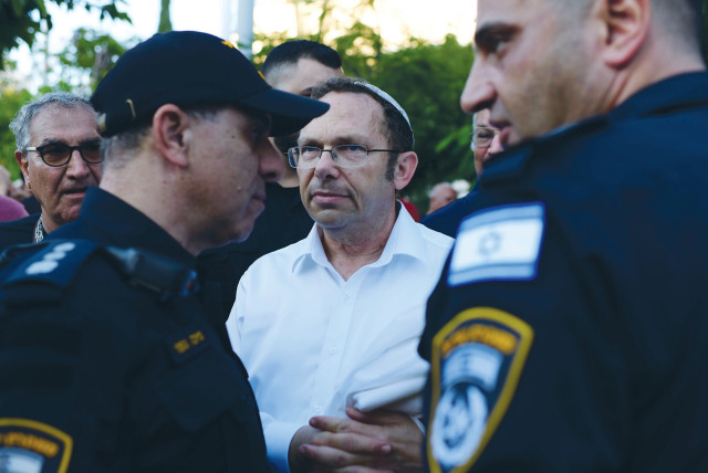  POLICE STAND guard as Rosh Yehudi head Rabbi Israel Zeira (center) looks on, at the onset of Yom Kippur, in Dizengoff Square in Tel Aviv, where the organization placed a partition between men and women for prayers.  (credit: TOMER NEUBERG/FLASH90)