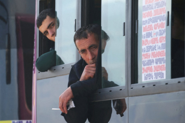  Refugees from Nagorno-Karabakh region sit in a bus upon their arrival in the border village of Kornidzor, Armenia, September 29, 2023. (credit: REUTERS/IRAKLI GEDENIDZE)