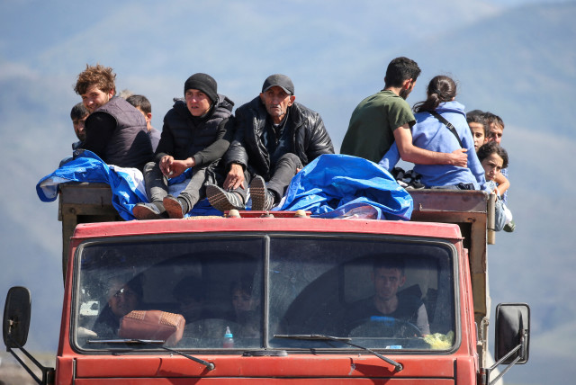  Refugees from Nagorno-Karabakh region ride in a truck upon their arrival at the border village of Kornidzor, Armenia, September 27, 2023 (credit: REUTERS/IRAKLI GEDENIDZE)