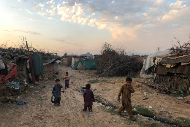  Children play outside their family's shelters at Afghan refugee camp in Islamabad, Pakistan February 13, 2020. Picture taken February 13, 2020. (credit: REUTERS/Charlotte Greenfield)