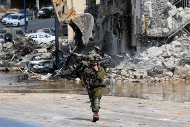  An Israeli soldier patrols near a police station which was the site of a battle following a mass infiltration by Hamas gunmen from the Gaza Strip, in Sderot, southern Israel October 8, 2023 (credit:  REUTERS/Ronen Zvulun)