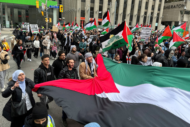  People carry a Palestinian flag during a rally in front of City Hall in Toronto, Ontario, Canada October 9, 2023. (credit: REUTERS/Kyaw Soe Oo)