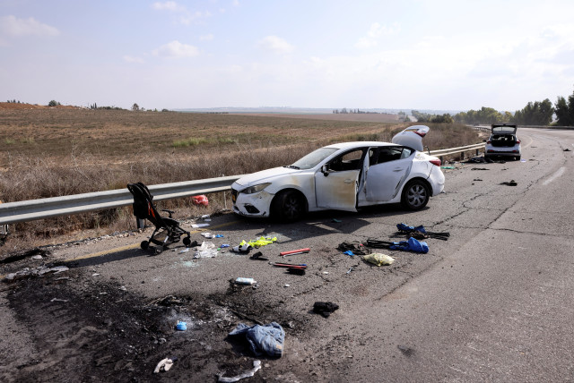 Personal belongings including a child's pram are seen on the road next to a car days after a mass infiltration by Hamas terrorists from the Gaza Strip, near Kibbutz Kfar Aza, in southern Israel, October 10, 2023 (credit: RONEN ZVULUN/REUTERS)