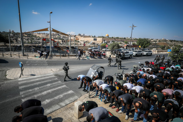  Israeli police guard while Palestinians perform Friday prayers in the East Jerusalem  Neighborhood of Ras Al Amud, October 13, 2023. (credit: JAMAL AWAD/FLASH90)