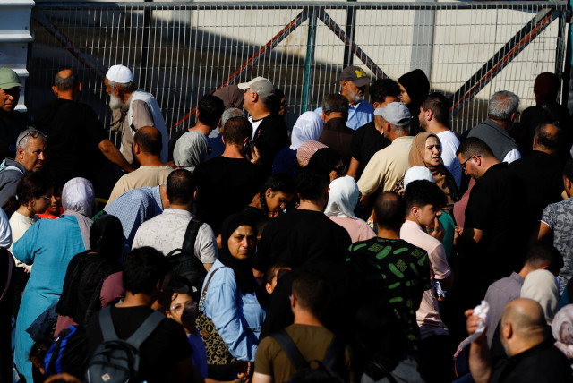 Palestinians with dual citizenship gather outside Rafah border crossing with Egypt in the hope of getting permission to leave Gaza, amid the ongoing Israeli-Palestinian conflict, in Rafah in the southern Gaza Strip October 16, 2023 (credit: REUTERS/IBRAHEEM ABU MUSTAFA)