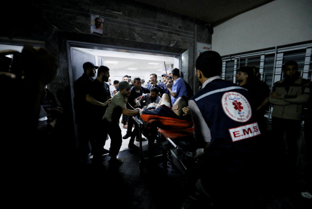  An injured person is assisted at Shifa Hospital after hundreds of Palestinians were killed in a blast at Al-Ahli hospital in Gaza  City, Gaza Strip, October 17, 2023 (credit: REUTERS/MOHAMMED AL-MASRI)
