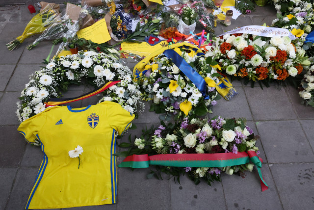 Flowers placed by Swedish Prime Minister Ulf Kristersson and Belgian Prime Minister Alexander De Croo are seen among other items left as a tribute to the victims two days after a gunman shot dead two Swedes, at the place of the shooting in Brussels, Belgium October 18, 2023. (credit: YVES HERMAN/REUTERS)