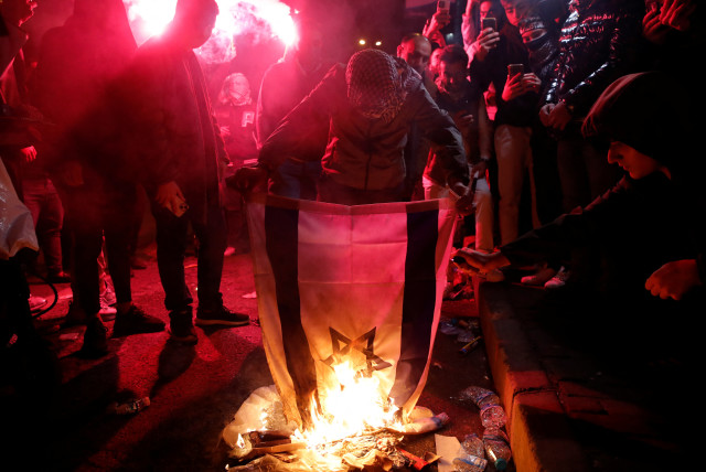  Pro-Palestinian demonstrators set an Israeli flag on fire during a protest near the Israeli Consulate as the conflict between Israel and Hamas continues, in Istanbul, Turkey October 18, 2023 (credit: REUTERS/DILARA SENKAYA)