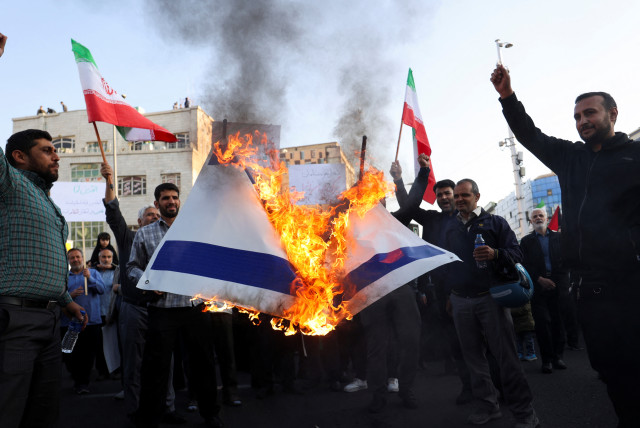  Protesters burn the Israeli flag during an anti-Israel protest in Tehran, Iran, October 18, 2023 (credit: Majid Asgaripour/ WANA via Reuters)