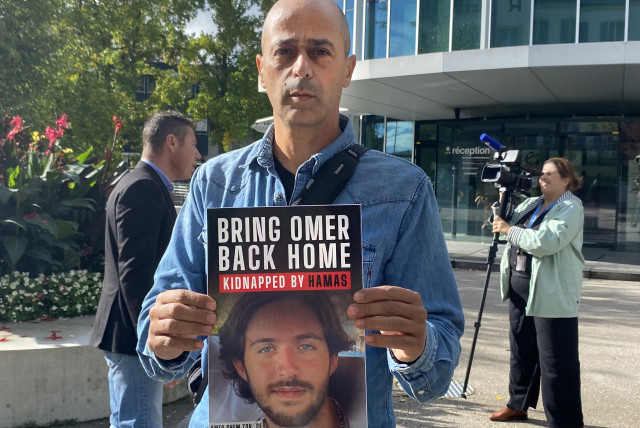  Assaf Shem Tov, uncle of Omer Shem Tov, a hostage taken to Gaza by Hamas, holds a sign calling for his nephew's release in front of the headquarters of the International Committee of the Red Cross (ICRC) in Geneva, Switzerland, October 20, 2023. (credit: REUTERS/Gabrielle Tetrault-Farber)