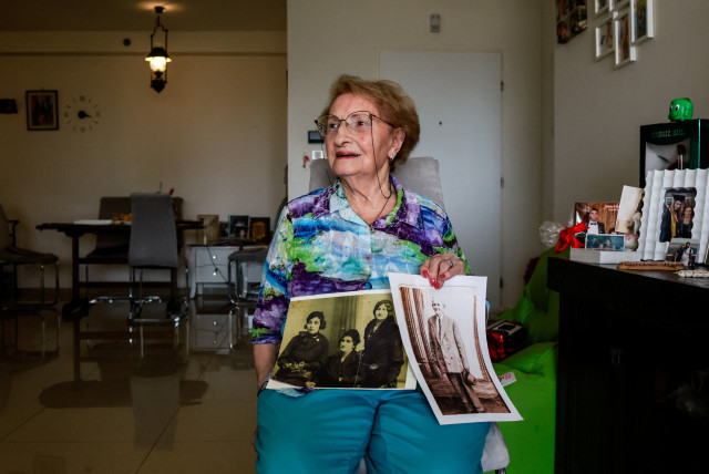  Holocaust survivor, Sarina Blumenfeld, 89, who endures flashbacks from the horrors of her past and now struggles to process the carnage following a deadly infiltration by Hamas gunmen, shows black and white photos during an interview with Reuters in her home in Ashdod, southern Israel, October 23 (credit: REUTERS/AMMAR AWAD)