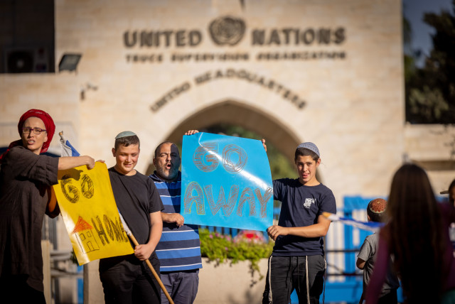  People waving Israeli flags as they protest against Secretary-General of the United Nations António Guterres outside the UN Headquarters in Jerusalem, October 25, 2023 (credit: YONATAN SINDEL/FLASH90)