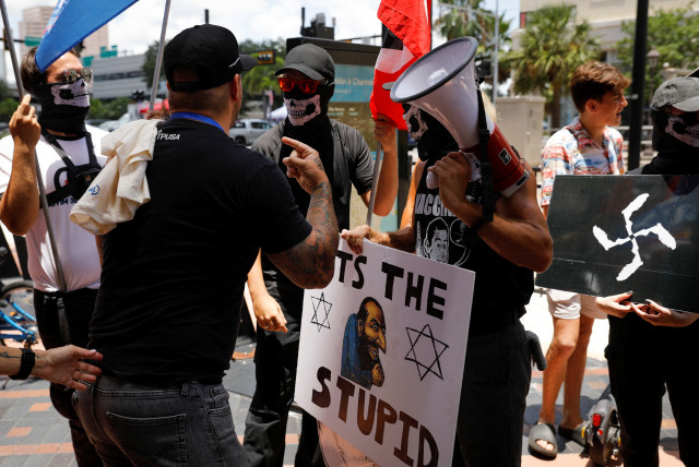  People wearing antisemitism and nazi symbols argue with conservatives during a protest outside the Tampa Convention Center where the Turning Point USA’s (TPUSA) Student Action Summit (SAS) is held, in Tampa, Florida, U.S. July 23, 2022. (credit: REUTERS/MARCO BELLO)