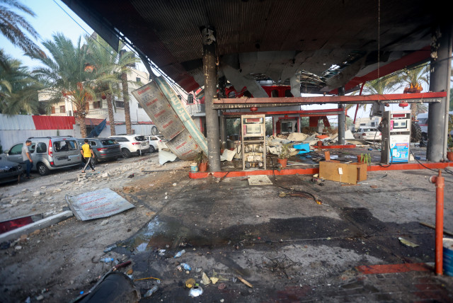  Palestinians walk past rubble of a gas station destroyed in an Israeli airstrike in the Gaza Strip, on October 24 2023. (credit: ATIA MOHAMMED/FLASH90)