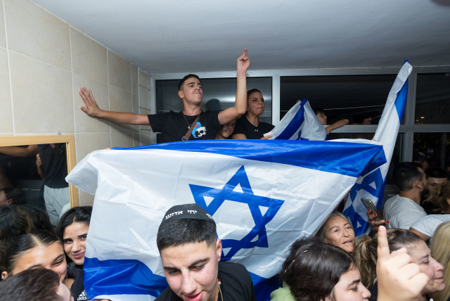  Israelis celebrate the release of IDF soldier Pvt. Ori Megidish from Hamas captivity, outside her home in Kiryat Gat, October 30, 2023. (credit: Liron Moldovan/Flash90)