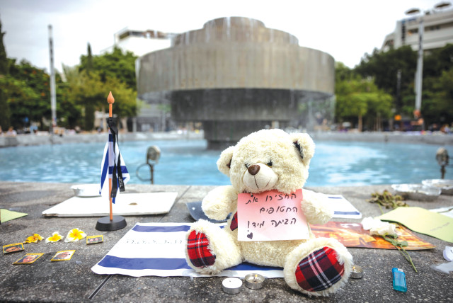  FLAGS, CANDLES, flowers, and a teddy bear with a sign that reads ‘Return the hostages home immediately!’ are placed at Dizengoff Square in Tel Aviv. (credit: Chaim Goldberg/Flash90)