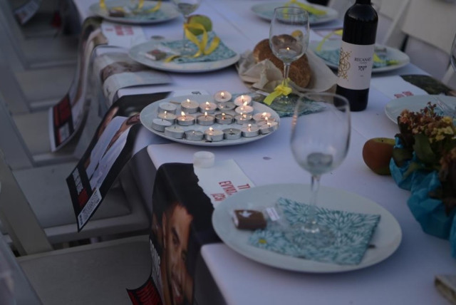 A symbolic Shabbat dinner table is set as families of hostages vow to not return home until their loved ones are freed. (credit: AVSHALOM SASSONI/ MAARIV)