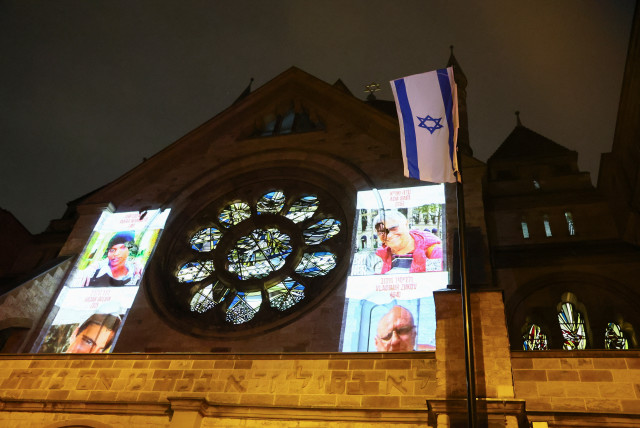  Pictures of people kidnapped during the October 7 attack on Israel by Palestinian Islamist group Hamas are projected on a synagogue, during a silent march from Cologne Cathedral to a synagogue to mark the eve of the commemoration of Kristallnacht, also known as the Night of Broken Glass, 85 years a (credit: REUTERS/WOLFGANG RATTAY)