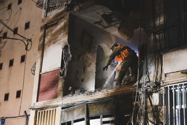 Israeli Home Front Command personnel clear an apartment that was struck by a Hamas rocket. (credit: IDF SPOKESPERSON'S UNIT)