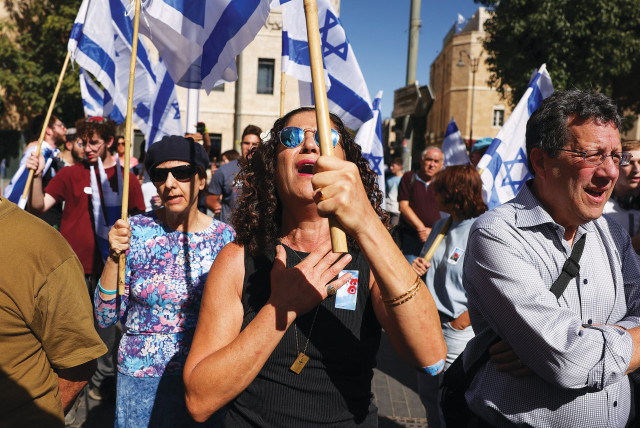  PEOPLE HOLD Israeli flags during a ceremony in early November in Jerusalem to mark the one-month anniversary of the October 7 Hamas massacre. (credit: RONEN ZVULUN/REUTERS)
