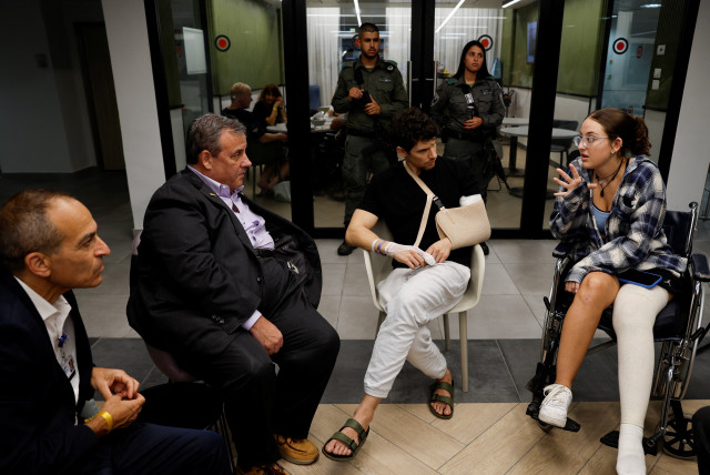  Former New Jersey Governor Chris Christie talks with Yadin, a soldier, and Sheerel Gabay, survivor of the Nova Festival, that were injured in the October 7 deadly attack by gunmen from terror group Hamas on southern Israel, at Sourasky Medical Center (Ichilov) in Tel Aviv, Israel  (credit: REUTERS/AMIR COHEN)
