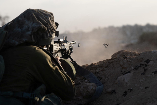  An Israeli soldier fires his weapon during the ongoing ground operation of the Israeli army against Palestinian Islamist group Hamas, in the Gaza Strip as seen in a handout picture released by the Israel Defense Forces on November 13, 2023. (credit: IDF/Handout via REUTERS)