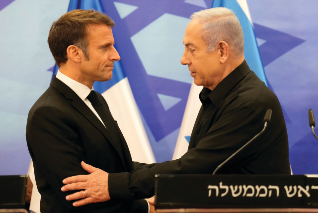  Prime Minister Benjamin Netanyahu and French President Emmanuel Macron embrace at a joint news conference in Jerusalem last month. Macron called for the anti-ISIS coalition to regroup against Hamas. (credit: CHRISTOPHE ENA/REUTERS)