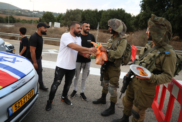  Druze residents hand out food to Israeli soldiers who guard on a road near the Israeli border with Lebanon, on October 9, 2023.  (credit: DAVID COHEN/FLASH 90)